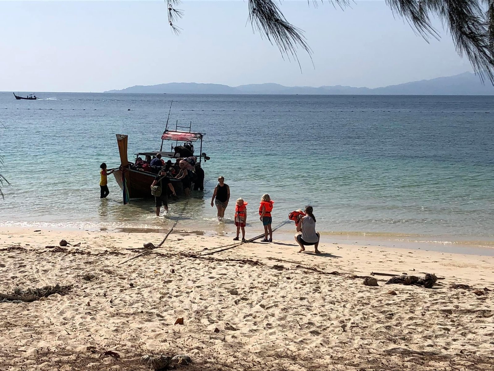 Guests arriving by longtail boat at the beach on Koh Bulon-Lae
